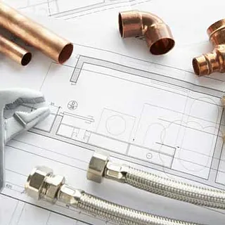 Copper pieces littered around a plumbing schematic